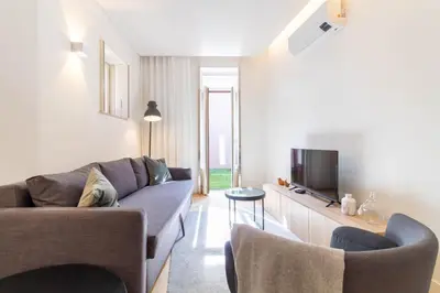 a living room with a couch and a tv at Caldeireiros 95 by LovelyStay in Porto