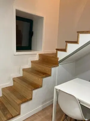 a staircase with a table and a television on the wall at Douro Villa 3 - Best View in Town in Vila Nova de Gaia