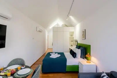 a small room with a bed and a table at Modern & Cozy Studio by HostWise in Porto