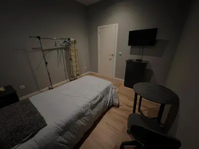 a bedroom with a bed and a chair and a television at Casa Carvalho Guest House Porto in Porto
