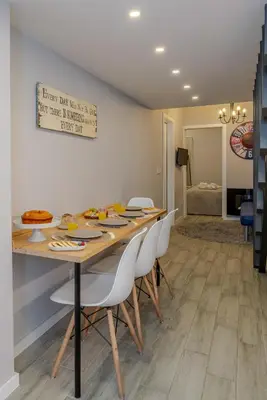 a dining room with a wooden table and white chairs at City Views Flats in Historic Porto by HostWise in Porto