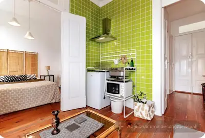 a room with a green wall with a bed and a kitchen at Ai Porto! Family 3 in Porto