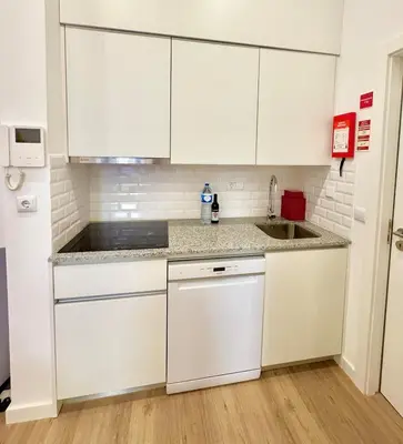 a kitchen with white cabinets and a sink at Douro Views by MyMoradia in Porto