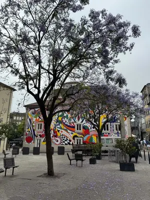 a park with trees and benches in front of a mural at Douro Views by MyMoradia in Porto