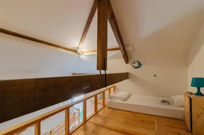 an attic room with a bench on the floor at Happy Porto Hostel in Porto