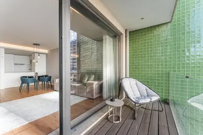 a bathroom with green tiled walls and a chair at GuestReady – City Center Apartment with Balcony in Porto