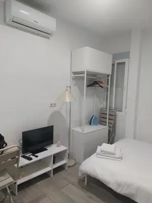 a white room with a bed and a desk with a television at PTLC225 Apartament T1 Porto Centro in Porto