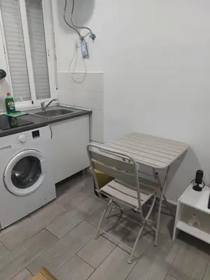 a table and a chair in a kitchen with a washing machine at PTLC225 Apartament T1 Porto Centro in Porto