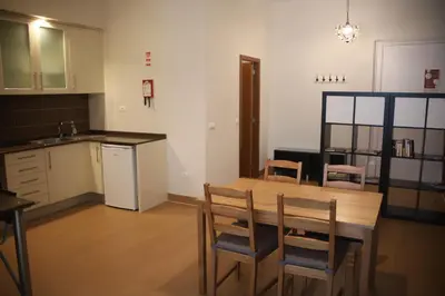 a kitchen with a wooden table and chairs at Pinho Apartments, Studios and Rooms in Porto