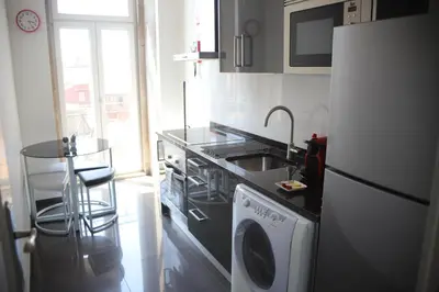 a kitchen with a stove and a washing machine at Pinho Apartments, Studios and Rooms in Porto