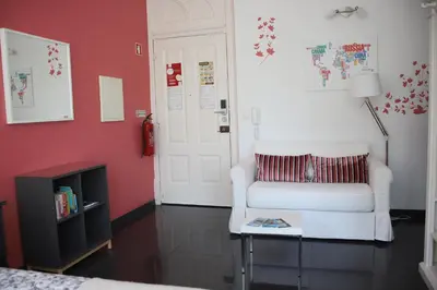 a living room with a white chair and a table at Pinho Apartments, Studios and Rooms in Porto