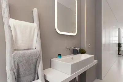 a bathroom with a white sink and a mirror at PortoWhite city lofts in Porto