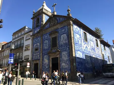 a blue building with a clock tower on a street at PortoWhite city lofts in Porto