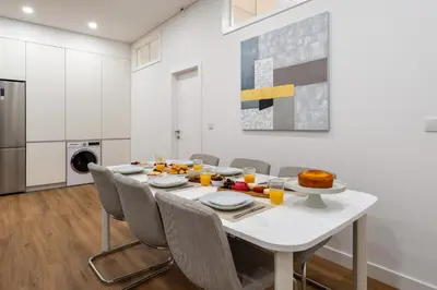 a white dining room with a white table and chairs at Open-Plan Apartment in Downtown Porto by HostWise in Porto