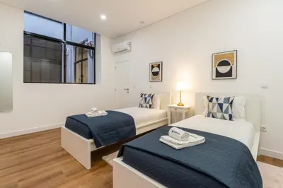 a bedroom with two beds and a window at Open-Plan Apartment in Downtown Porto by HostWise in Porto