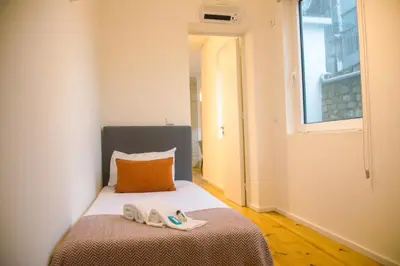 a bedroom with a bed with two slippers on it at Belas Artes Apartments in Porto