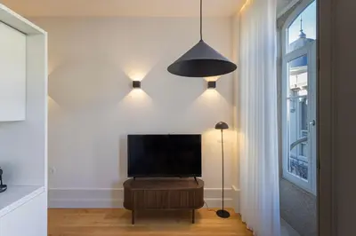 a living room with a flat screen tv and a lamp at ApartmentsPorto - Alexandre Braga in Porto