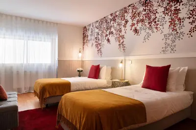 a hotel room with two beds and a window at Ouro Views to Douro River in Porto
