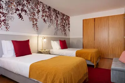 a hotel room with two beds and a couch at Ouro Views to Douro River in Porto