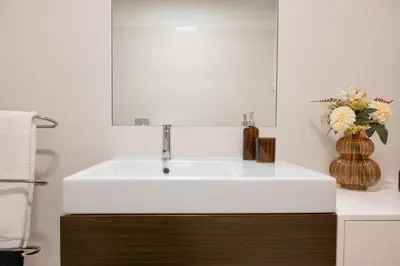 a bathroom with a white sink and a vase of flowers at Ouro Views to Douro River in Porto