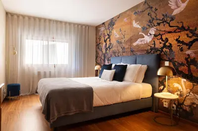 a bedroom with a large bed with a floral wall at Ouro Views to Douro River in Porto