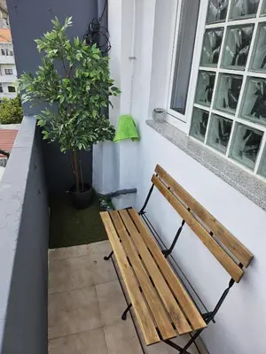 a wooden bench sitting next to a window at Boavista Family T3 in Porto