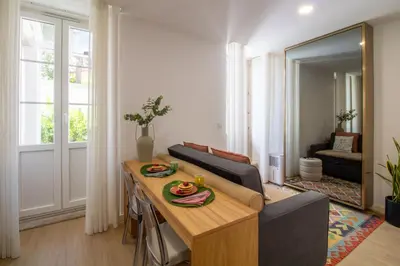 a living room with a table and a couch at Santa Catarina Studio w Patio by LovelyStay in Porto