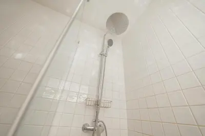 a shower in a bathroom with white tiled walls at Downtown Comfort Apartment by Vacationy in Porto