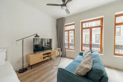 a living room with a blue couch and a tv at Downtown Comfort Apartment by Vacationy in Porto