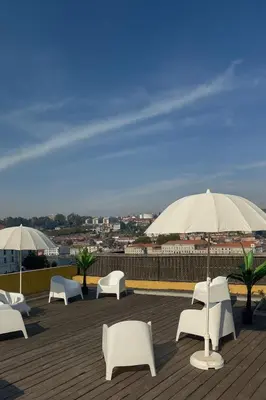 a group of white chairs and umbrellas on a roof at Douro Villa 13 - Best View in Town in Vila Nova de Gaia