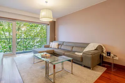 a living room with a couch and a glass table at Premium Flat w/ Pool, Gym & Garage by HostWise in Vila Nova de Gaia