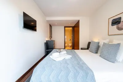 a hotel room with a bed with a blue blanket at Premium Flat w/ Pool, Gym & Garage by HostWise in Vila Nova de Gaia