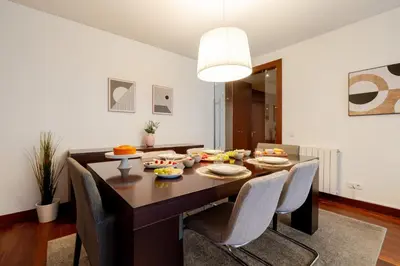 a dining room with a table and chairs with food on it at Premium Flat w/ Pool, Gym & Garage by HostWise in Vila Nova de Gaia