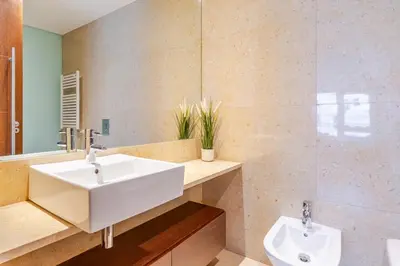 a bathroom with a white sink and a mirror at Premium Flat w/ Pool, Gym & Garage by HostWise in Vila Nova de Gaia