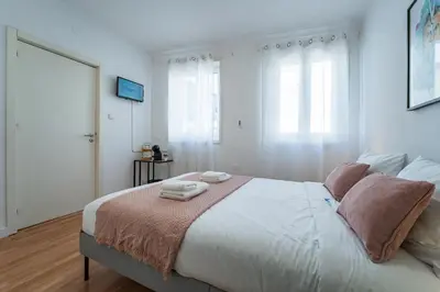 a white dining room with a white table and chairs at Oporto Maria Pia Suite 1 in Porto
