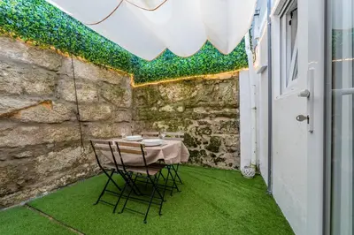 a table and chairs on a patio with green grass at Oporto Maria Pia Apartment Whith Terrace 2 in Porto