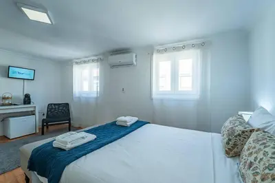 a white dining room with a white table and chairs at Oporto Maria Pia Suite 3 in Porto