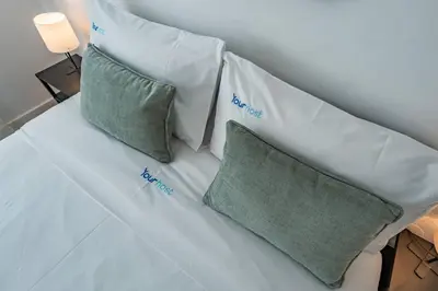 a white couch with two green pillows on it at Oporto Maria Pia With Terrace Suite 4 in Porto