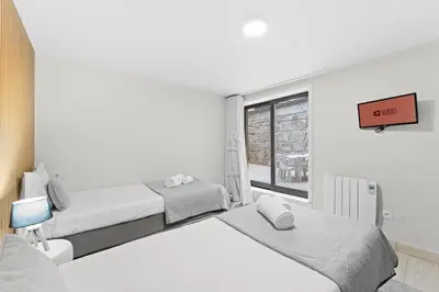 a white room with two beds and a window at GuestReady - Modern Porto's retreat in Porto