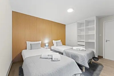 two beds in a small room with white sheets at GuestReady - Modern Porto's retreat in Porto