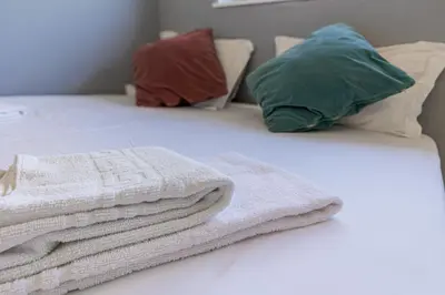 a bed with towels and pillows on it at Your Home at Porto in Porto