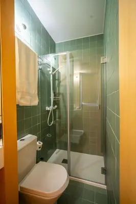 a bathroom with a toilet and a glass shower at Belmont Riverside 5m in Porto