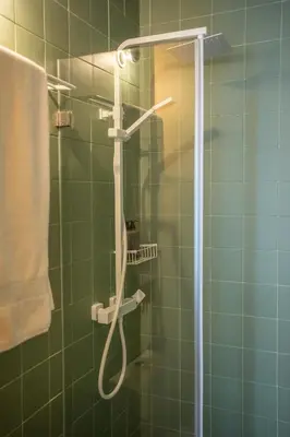 a shower in a green tiled bathroom at Belmont Riverside 5m in Porto