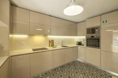 a kitchen with white cabinets and a sink at Cardosas Square Living in Porto