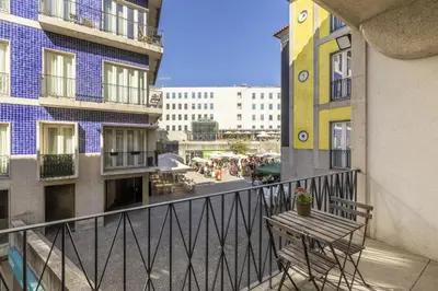 a balcony with a wooden bench and buildings at Cardosas Square Living in Porto