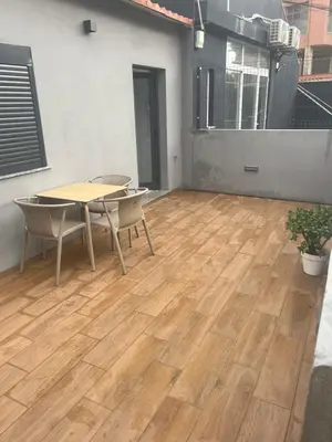 a patio with a table and chairs and a wooden floor at Candal house in Vila Nova de Gaia