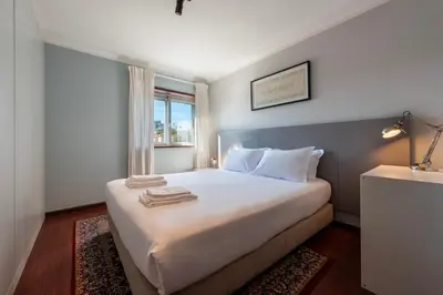 a bedroom with a large white bed with a window at NEW! The Porto Wine Cellars Penthouse in Vila Nova de Gaia
