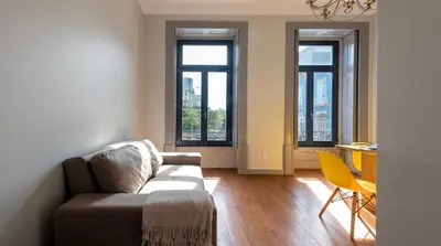 a living room with a couch and two windows at NEW! Blue Pearl Apartment in Porto