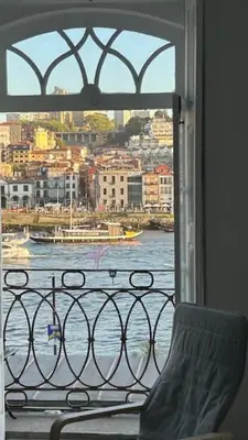 a view of the water from a window with a chair at Ribeira São Nicolau 1 in Porto