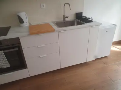 a white kitchen with a sink and a stove at Ribeira São Nicolau 1 in Porto